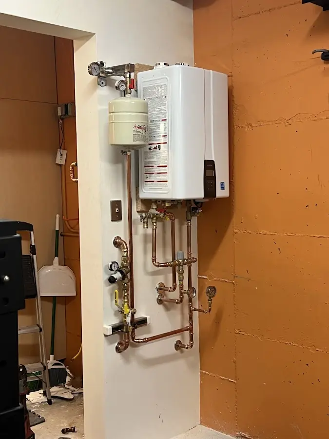 Plumbing technician inspecting water heater connections in Blairsville